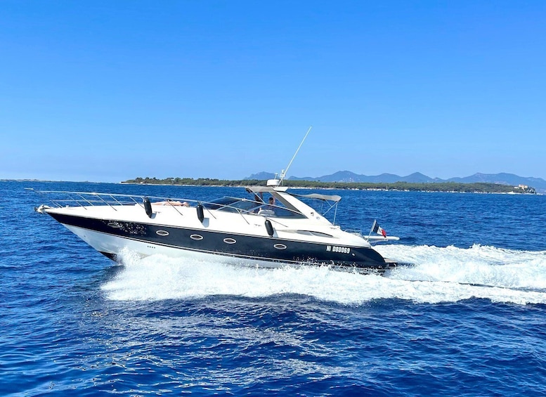 A speedboat on a clear blue sea with a distant shoreline and mountains. 5