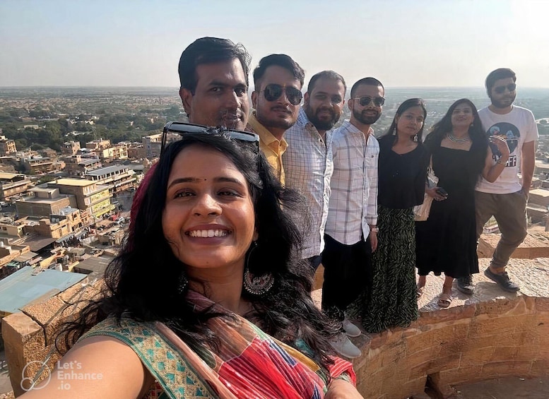 A group of people standing on a cliff overlooking a cityscape. 3