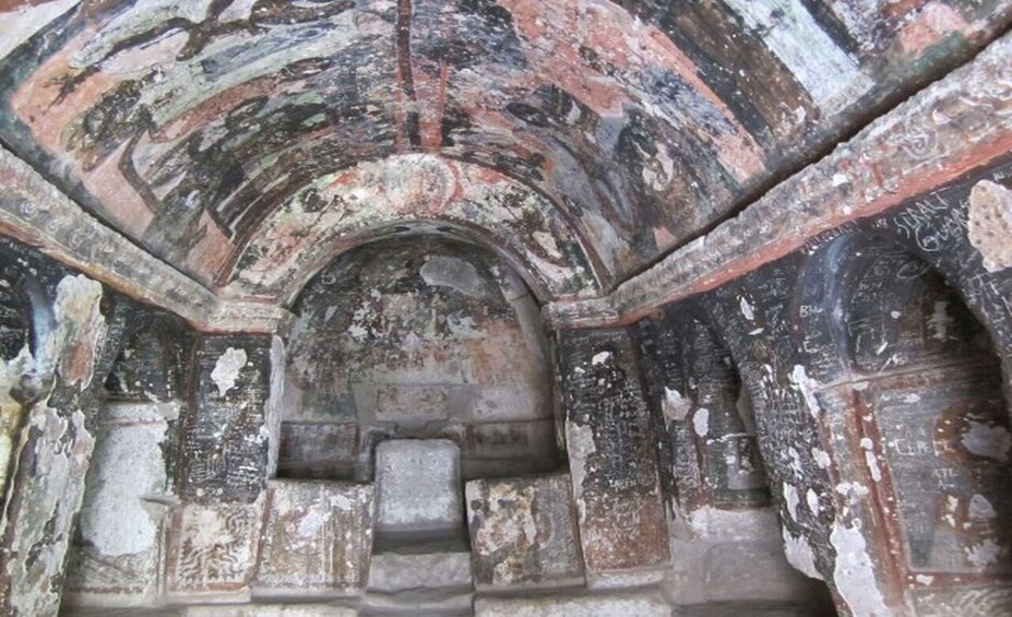 An ancient stone structure with weathered arches and inscriptions. 4