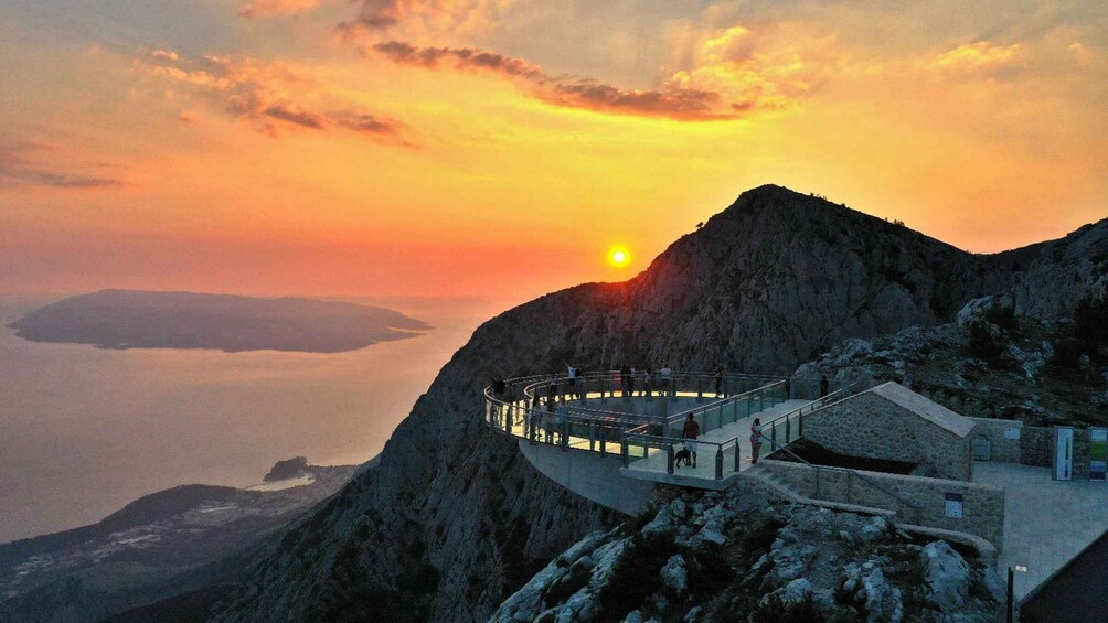 A sunset over a mountainous landscape with a viewing platform. 3