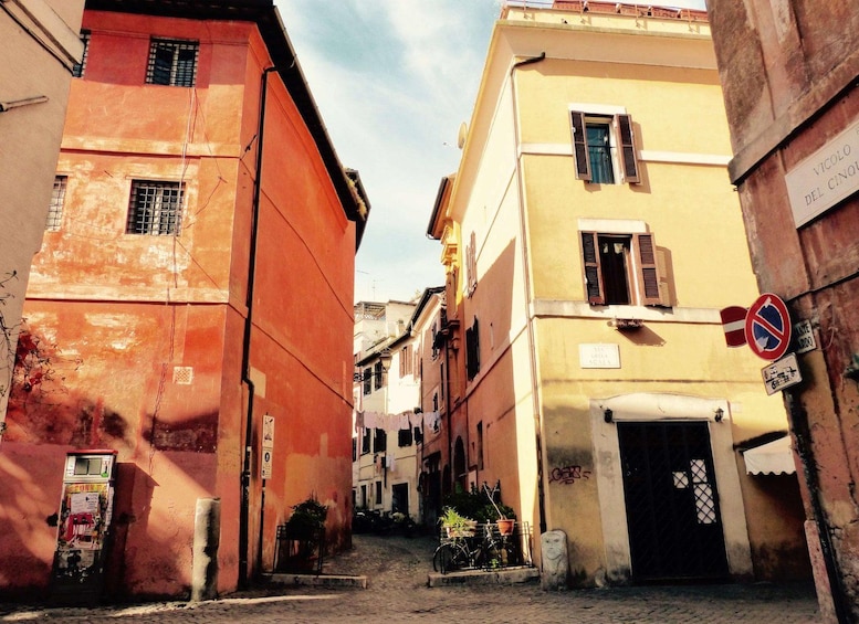 A narrow street with buildings on either side, a no parking sign, and a bicycle parked in front of a building. 4