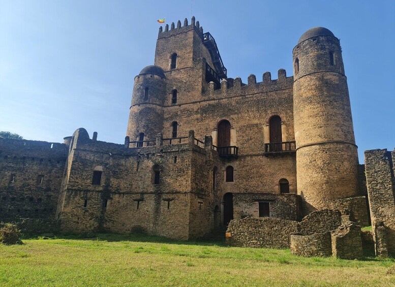 A medieval castle with two prominent towers, a drawbridge, and a flag on top. 1