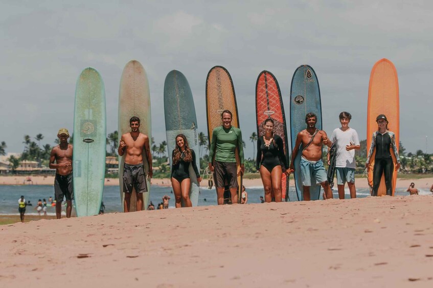 A group of people with surfboards on a beach. 1