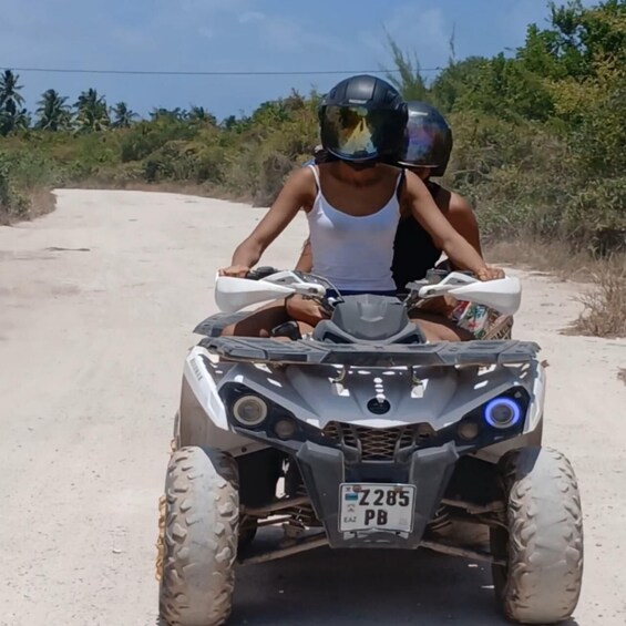 A person riding a four-wheeled ATV on a dirt road with a license plate reading 'Z285 PB'. 5