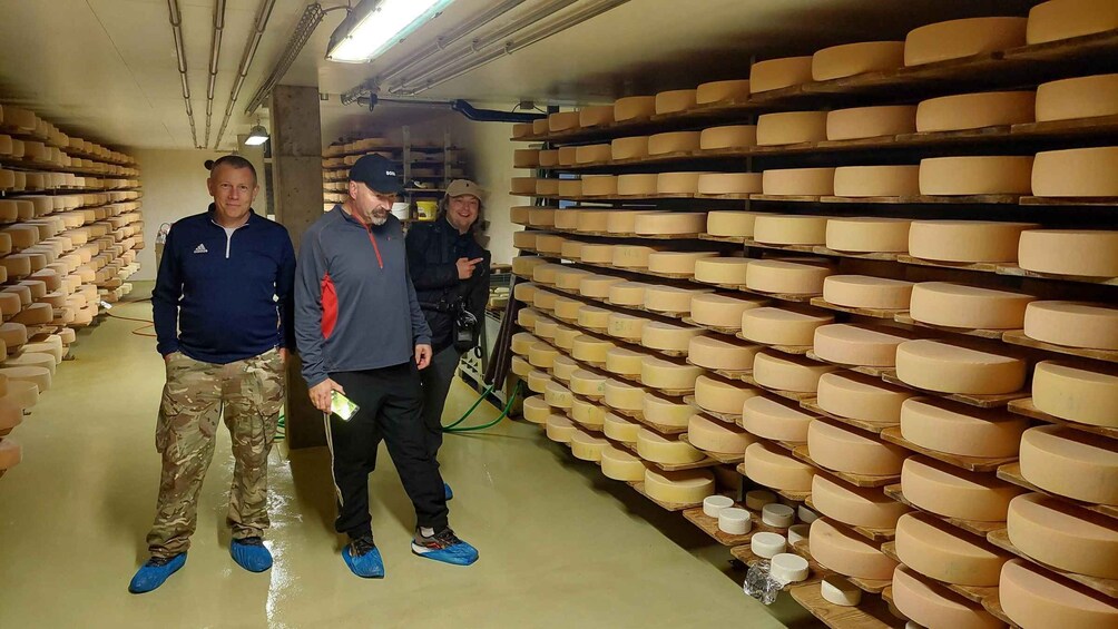 A cheese aging room with rows of cheese wheels. 3