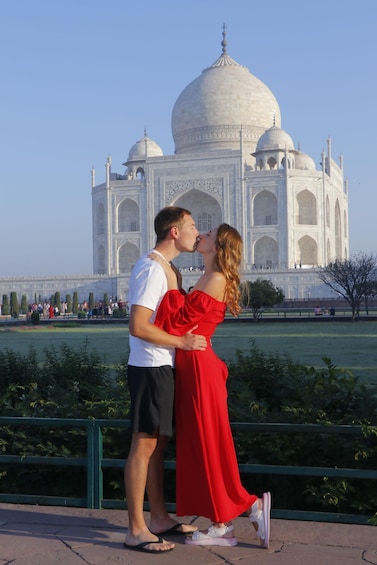 A couple kissing in front of the Taj Mahal. 1