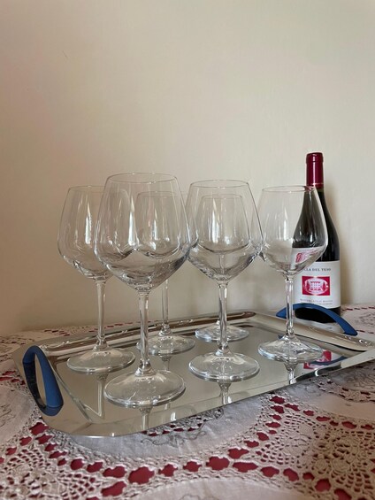 Four wine glasses on a tray with a bottle of wine in the background. 3
