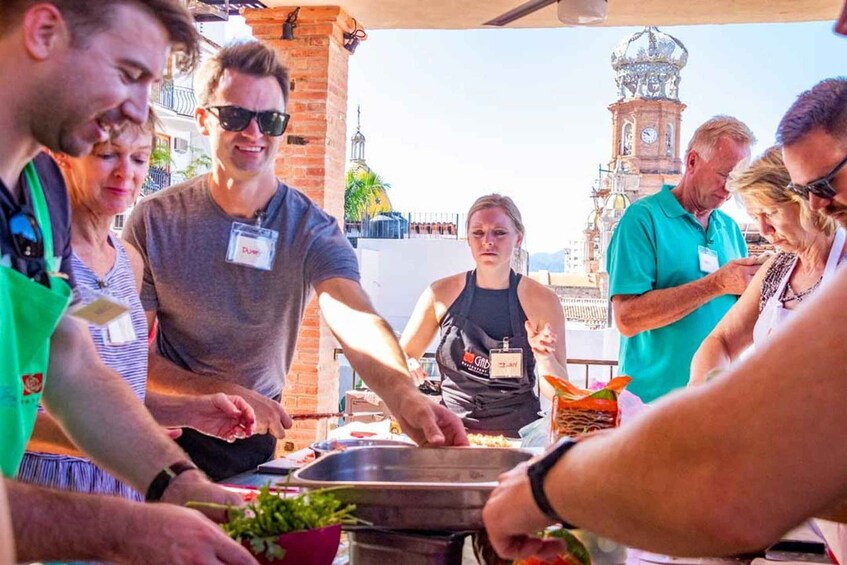A group of people at an outdoor food event with a historic building in the background. 4
