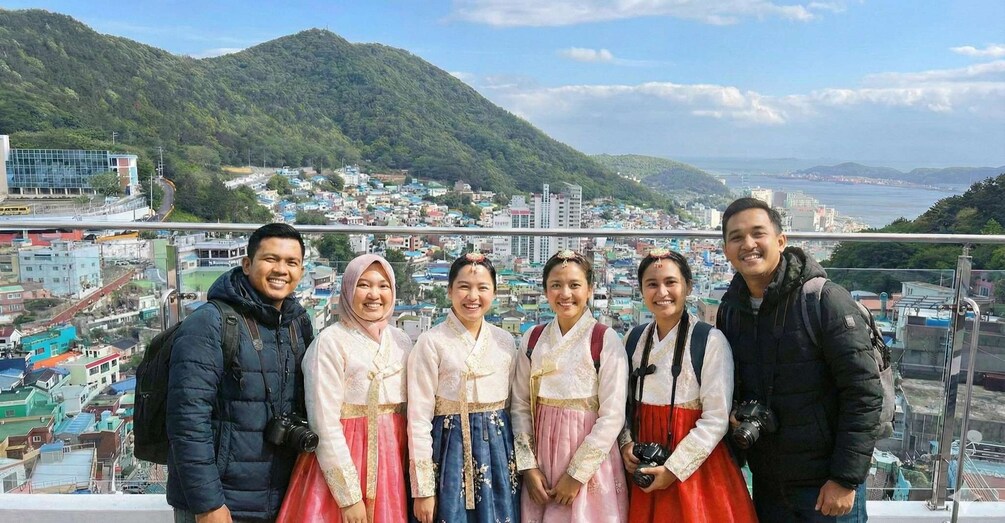 A group of people on a balcony overlooking a city with mountains in the background. 5