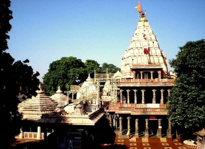 A temple with a large spire, smaller shrines, and a courtyard with patterned flooring. 2