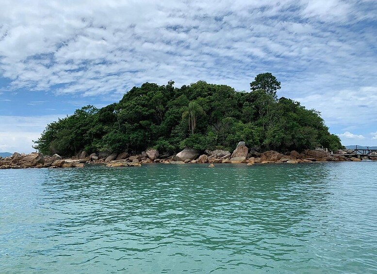A lush, forested island surrounded by clear turquoise waters. 3