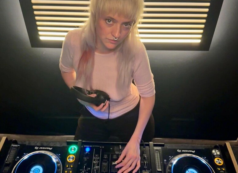 A person operating DJ equipment with a mixer and turntables. 3