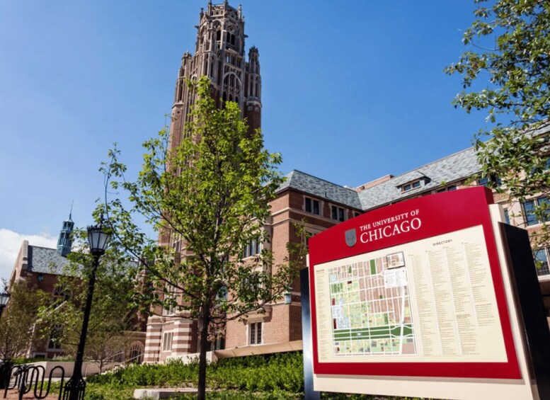 A university building with a red signboard and a tall tower in the background. 5