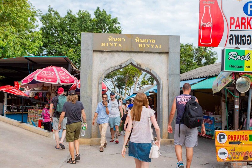 A bustling street with a Coca-Cola sign, a Rock Reggae sign, and a sign for HINTA HINYAI. 5