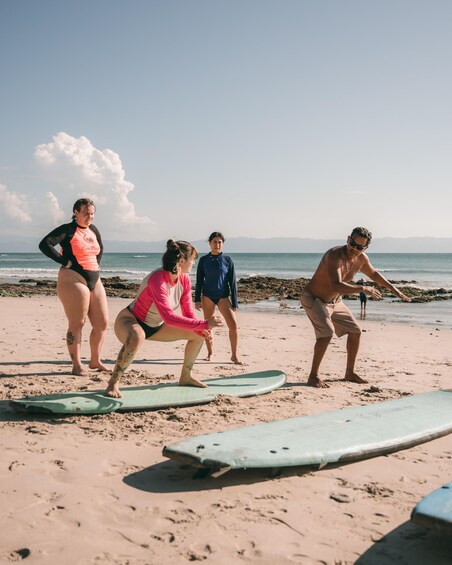 A group of people on a beach with surfboards. 2