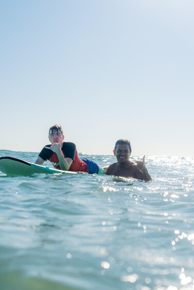 Two people lying on surfboards in the ocean. 5