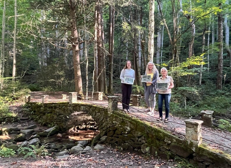 Three people standing on a stone bridge in a forest. 2