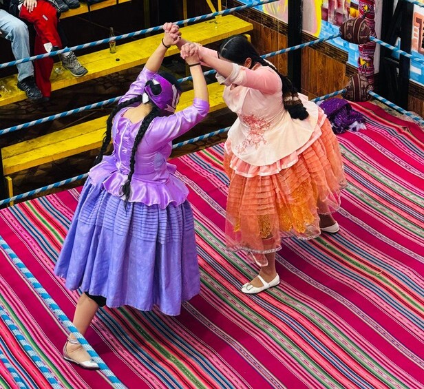 Two individuals in traditional costumes holding hands in a ring. 1