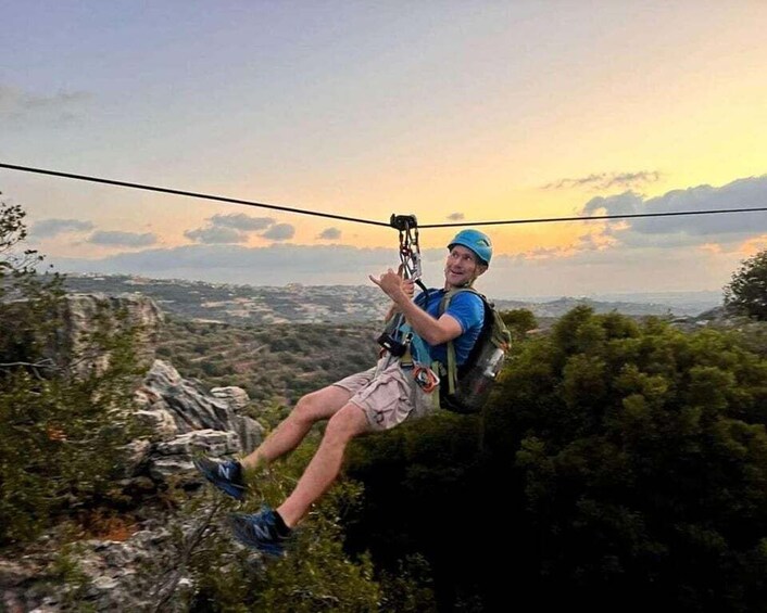 A person zip-lining over a mountainous landscape with a sunset in the background. 5