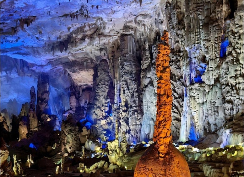 A cave with stalactites and stalagmites, illuminated by artificial lighting. 3