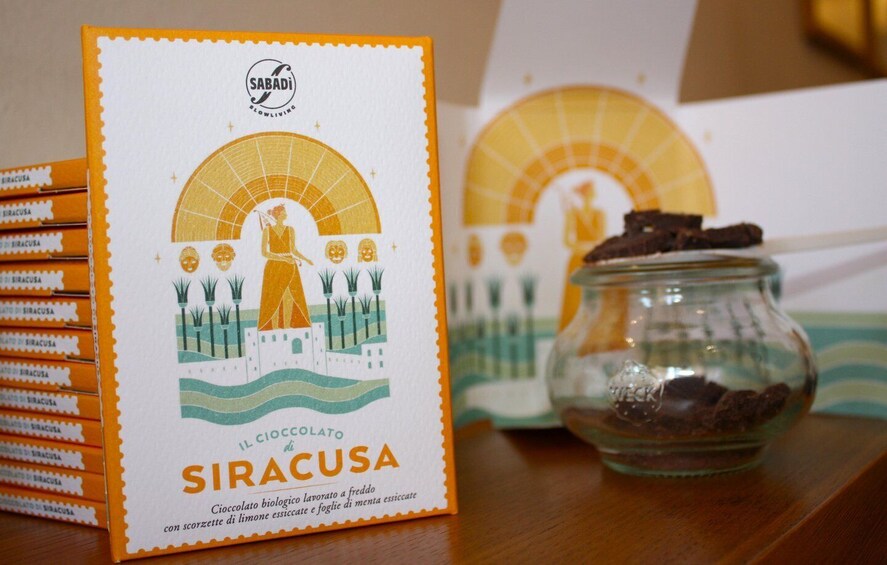 A box of 'SIRACUSA' chocolate with a woman and palm trees illustration, and a jar of chocolate. 3