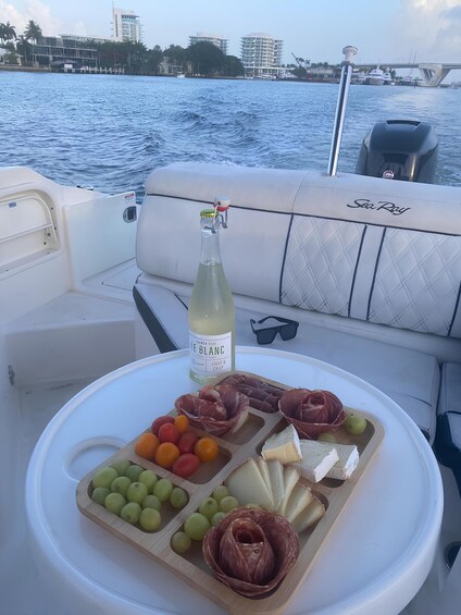 A boat with a table set with food and a bottle of wine. 5
