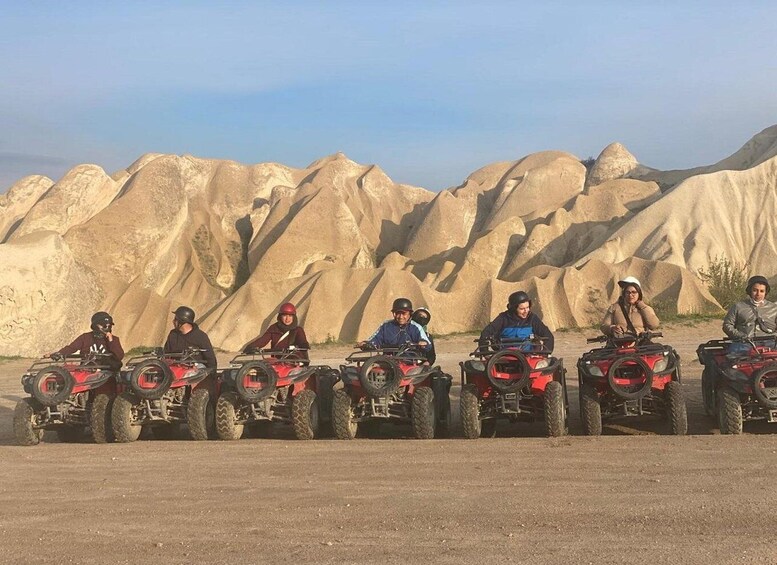 A group of people on ATVs in a desert landscape with large rock formations. 4