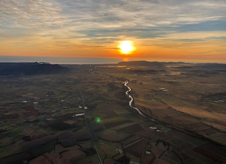 A river winding through agricultural fields during sunset. 3