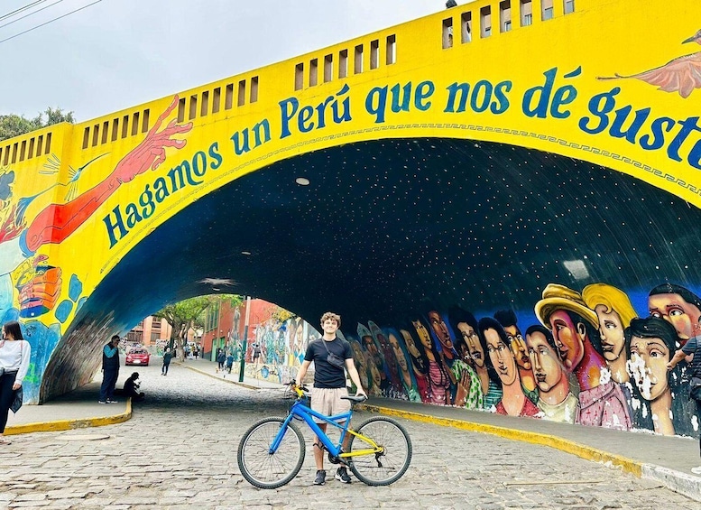 A colorful mural under a yellow archway with a bicycle in the foreground. 3
