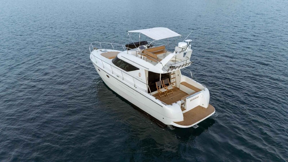 A white yacht with a covered deck and a cabin. 1