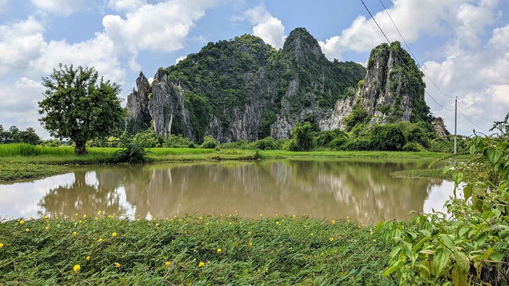 A calm lake surrounded by lush greenery and towering limestone cliffs. 1