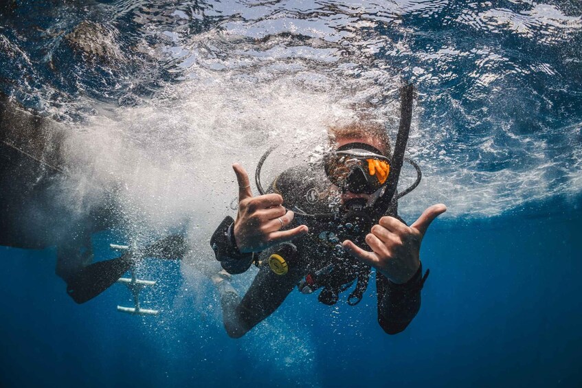 A person underwater with scuba gear, bubbles, and a diver's mask. 5
