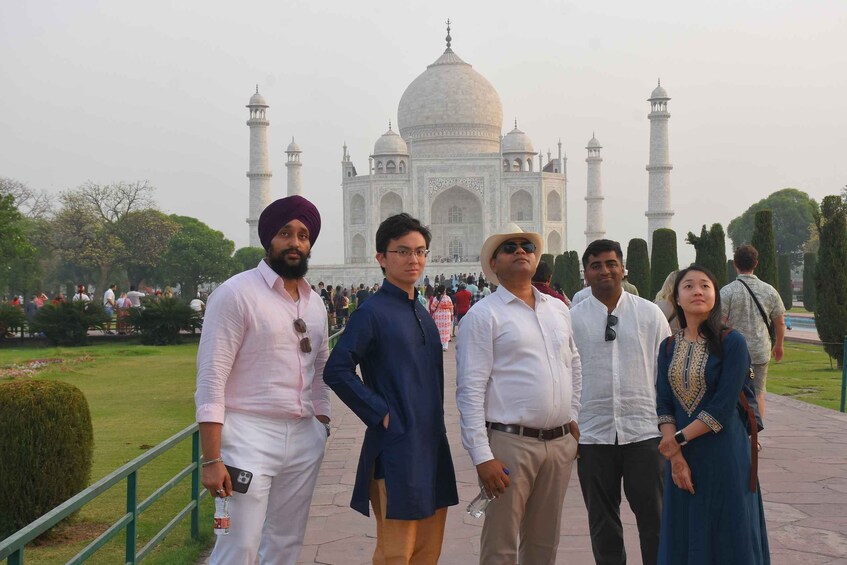 A group of people standing in front of the Taj Mahal. 1