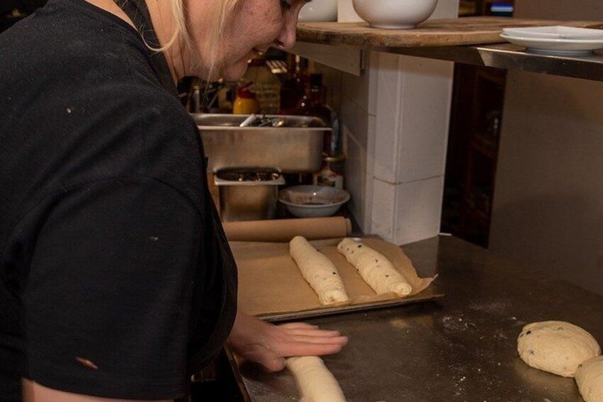 A person rolling dough on a kitchen counter. 5