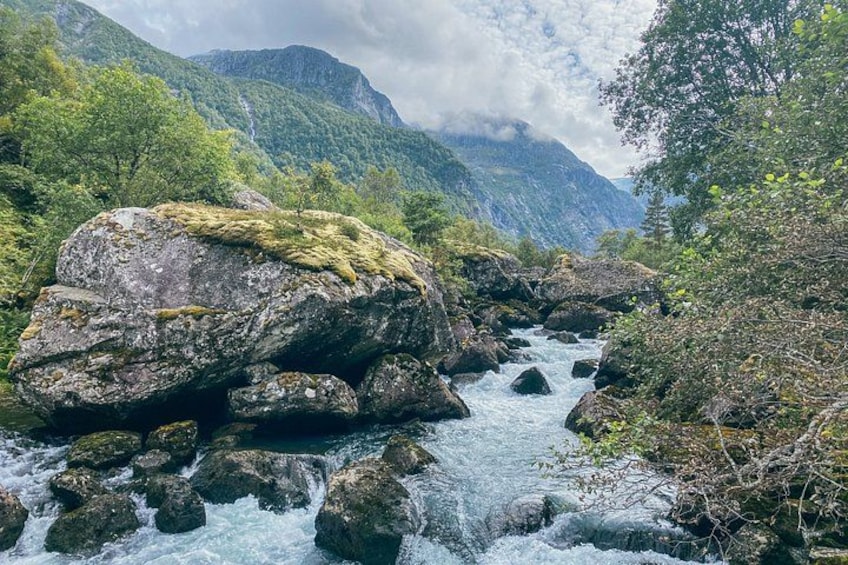 A river flowing through a rocky landscape with mountains in the background. 3