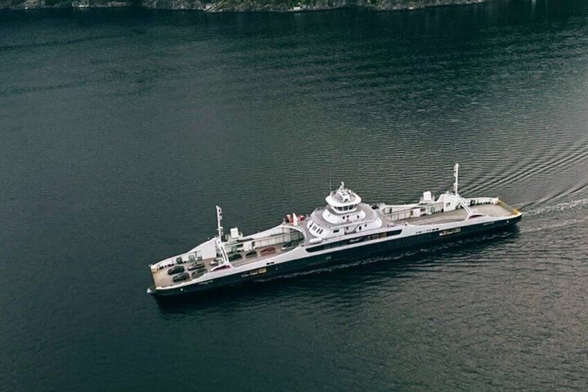 A large, white ship with multiple decks and a superstructure, moving through calm water. 3