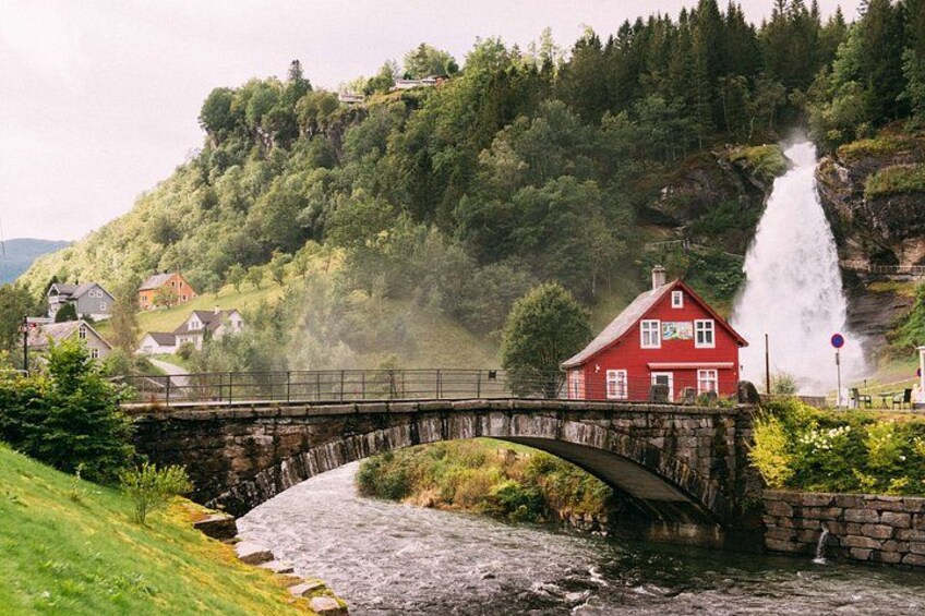 A red house, a stone bridge, a waterfall, and a river. 2