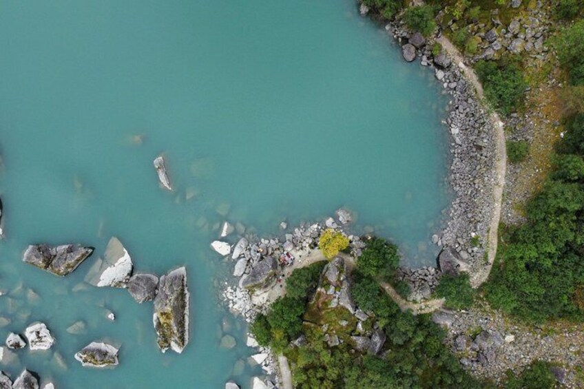 A turquoise coastal area with rocky outcrops and dense greenery. 2