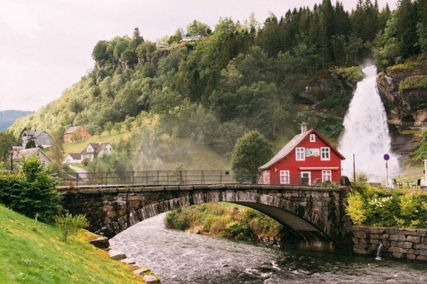 A red house, a stone bridge, a waterfall, and a river. 5