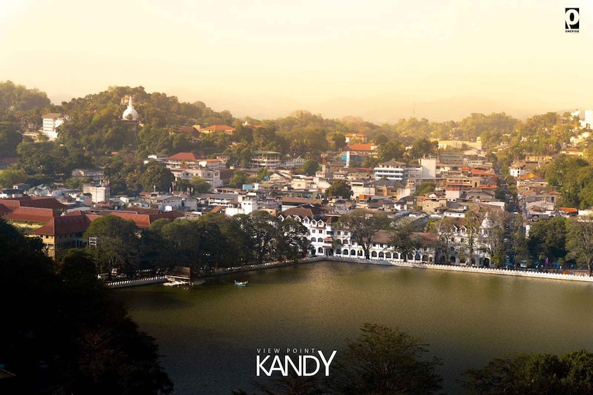 Vista panorámica de Kandy, con un lago, edificios y un destacado templo blanco en una colina. 3