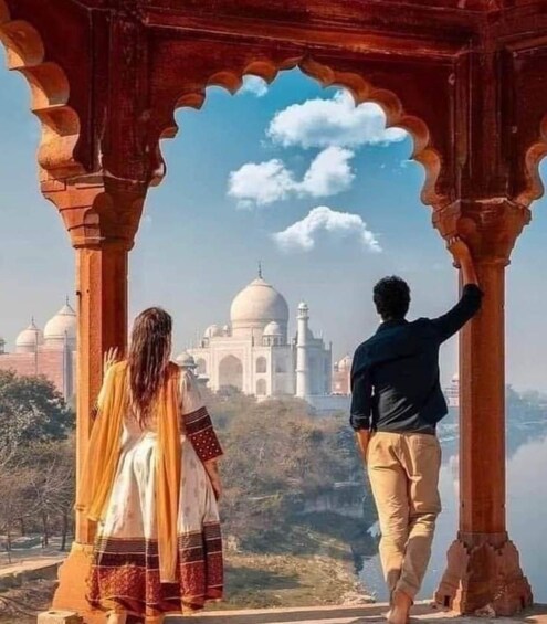 A couple standing in an archway overlooking the Taj Mahal. 2