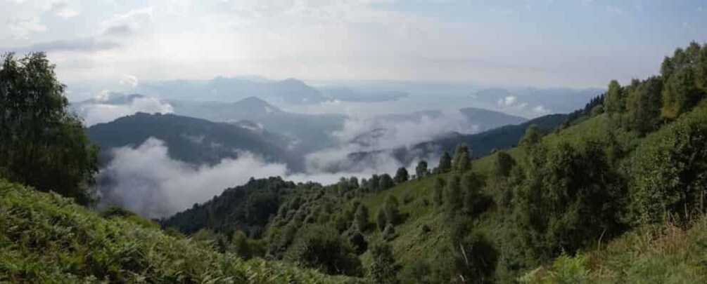 A mountainous landscape with dense forests and a valley shrouded in mist. 4