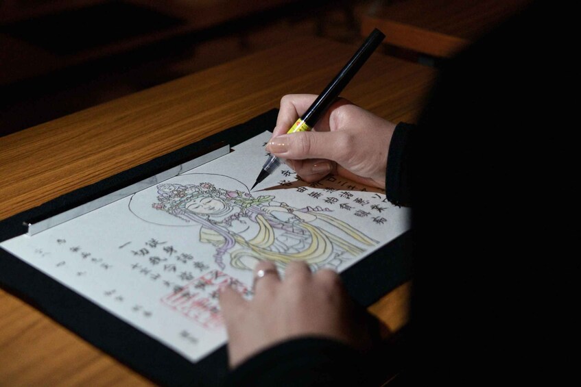 A person coloring a drawing on paper. 5