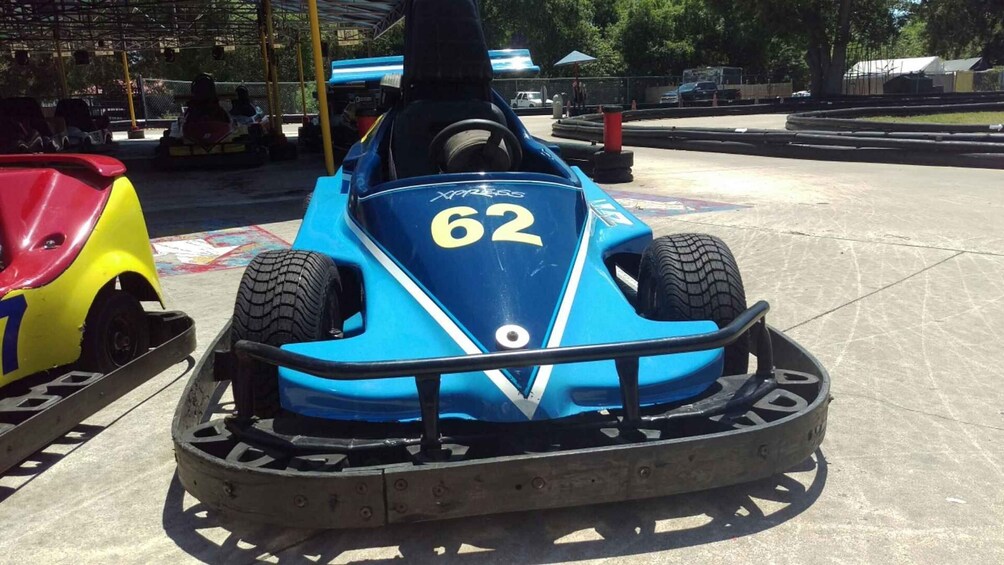 A blue go-kart with the number 62 parked on a concrete surface. 3