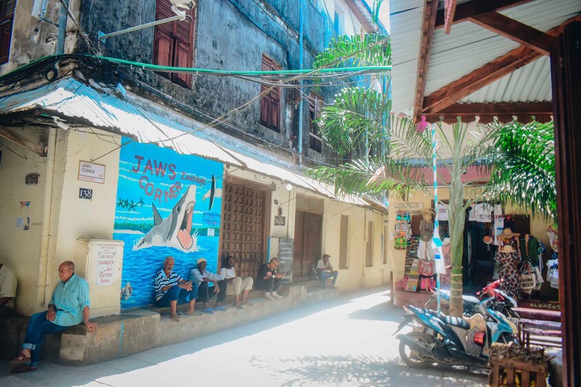 A street with a building featuring a mural of a shark and the text 'JAWS CORNER.' 3