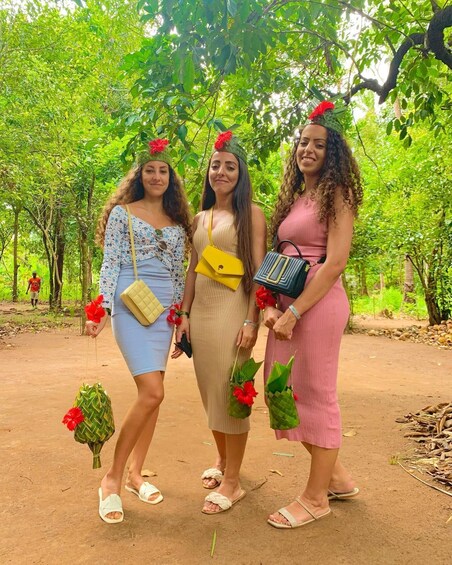 Three women in a forested area with trees and greenery. 1