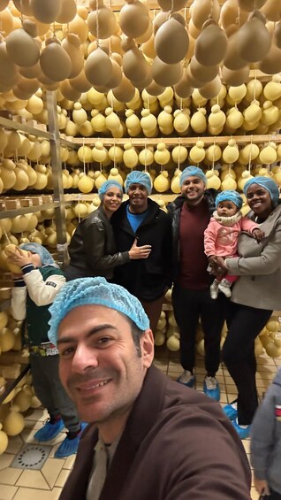 A group of people in a room filled with hanging yellow objects. 2