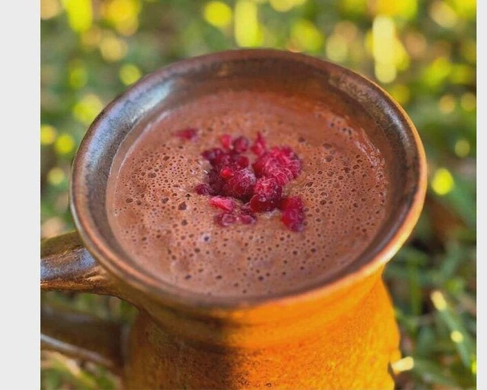 A traditional Turkish coffee cup with a frothy top and a garnish of red berries. 5