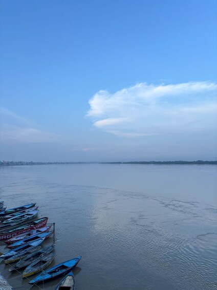 A calm river with boats docked on the left. 1