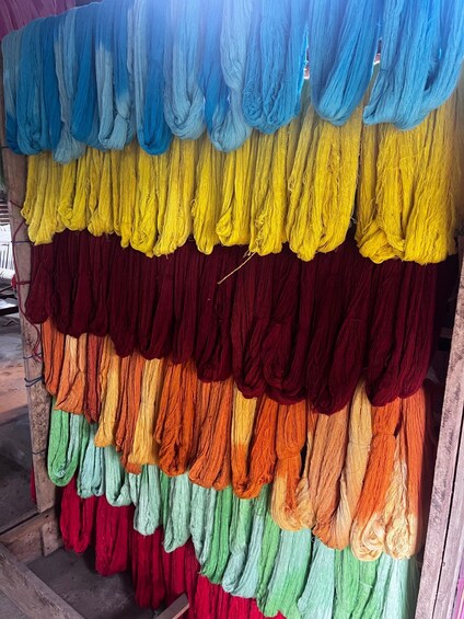 A display of yarn in various colors hanging vertically. 2